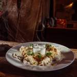 Pierogi** ruskie gotowane LUB smażone (8 szt.), śmietana